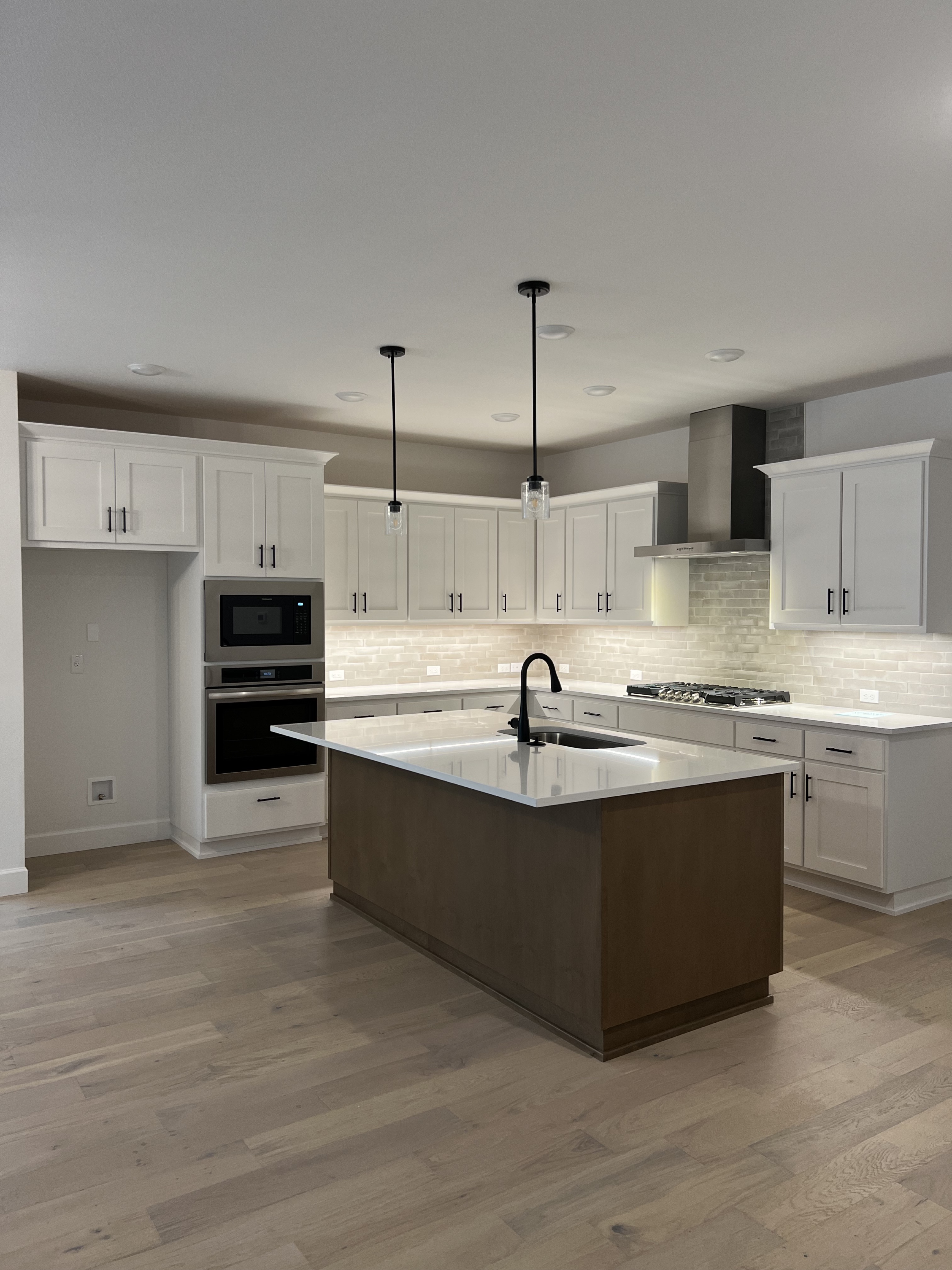 White kitchen with light oak flooring